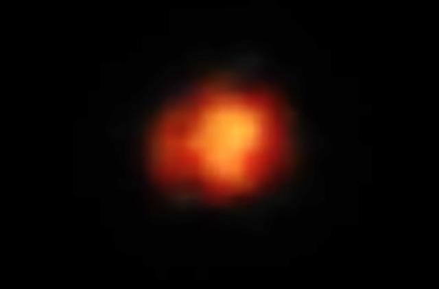 A glowing red blob in black space. It’s an image of Maisie’s galaxy, a system calculated to be from 390 million years after the Big Bang.  