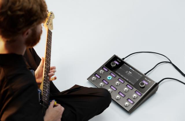A bearded hipster plays guitar with the Tone Master Pro. 