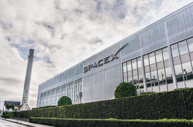 Dec 8, 2019 Hawthorne / Los Angeles / CA / USA - SpaceX (Space Exploration Technologies Corp.) headquarters; Falcon 9 rocket displayed on the left; SpaceX is a private American aerospace manufacturer