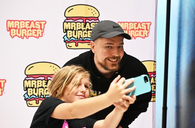 EAST RUTHERFORD, NEW JERSEY - SEPTEMBER 04: Global YouTube star MrBeast (R) poses with fan at the launch of the first physical MrBeast Burger Restaurant at American Dream on September 4, 2022 in East Rutherford, New Jersey. (Photo by Dave Kotinsky/Getty Images for MrBeast Burger)