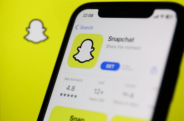 Snapchat on App Store displayed on a phone screen and Snapchat logo displayed on a screen in the background are seen in this illustration photo taken in Krakow, Poland on Auguust 13, 2023. (Photo by Jakub Porzycki/NurPhoto via Getty Images)