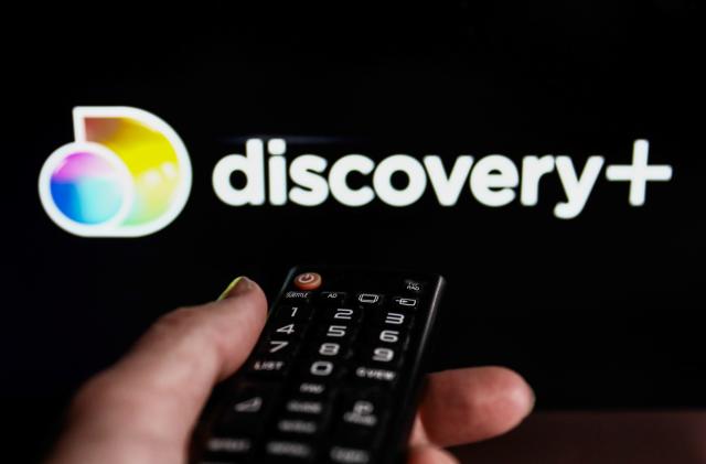 TV remote control and Discovery+ logo displayed on a laptop screen are seen in this illustration photo taken in Krakow, Poland on February 9, 2022. (Photo illustration by Jakub Porzycki/NurPhoto via Getty Images)